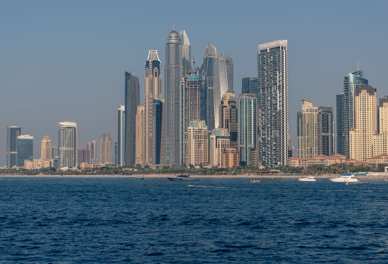 The towers of Dubai Marina seen across open water on a clear day