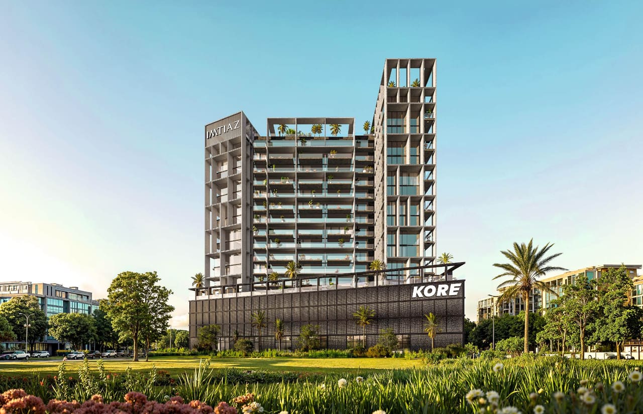 Render of the KORE by Imtiaz tower in Dubai Land Residence Complex, a slim residential block rising from a dark podium framed by parkland