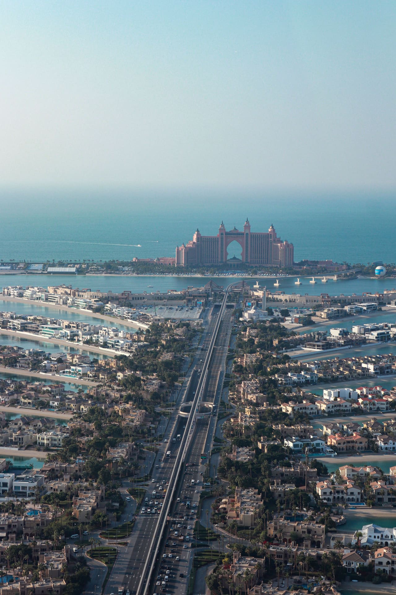 Palm Jumeirah from the air in daylight, the trunk road running out to the hotel at the crescent